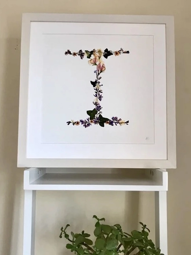 Pressed Wildflower Letter Print, a wildflower alphabet letter print sitting framed. 