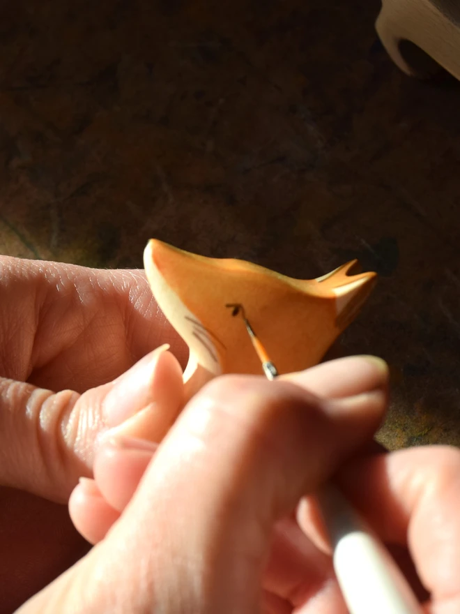 wooden fox toy being handpainted