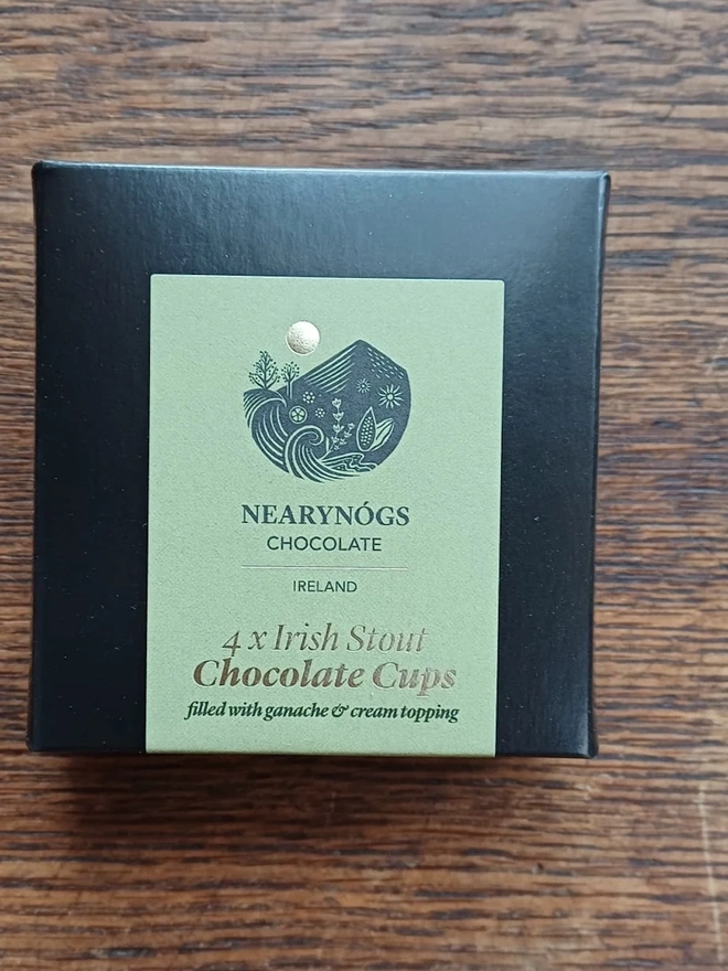 Irish Stout Chocolate Cups Made With Real Stout (Box Of 4), a box of chocolates sitting on a wooden surface. 
