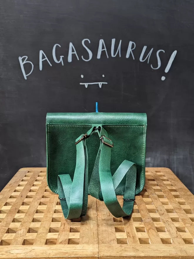 Back view of green leather  'Bagasaurus' backpack showing adjustable strap detail.