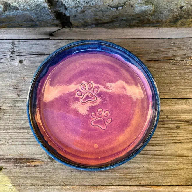 Landscape Cat Bowl, a colourful cat bowl placed on a wooden surface against a brick backdrop. 
