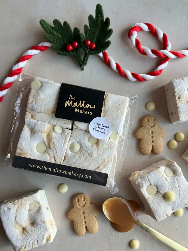 The-Mallow-Makers-looking-down-on-ginger-and-white-chocolate-marshmallows-with-ingredients-scattered-and christmas-ribbon