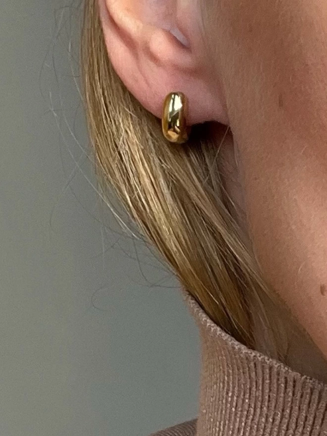 Chubby gold hoop earring on a model
