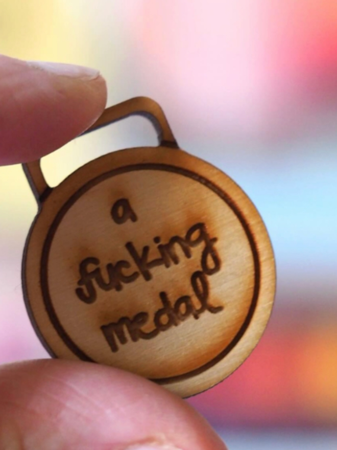 Wooden Fucking Medal. A small, circular piece of wood.