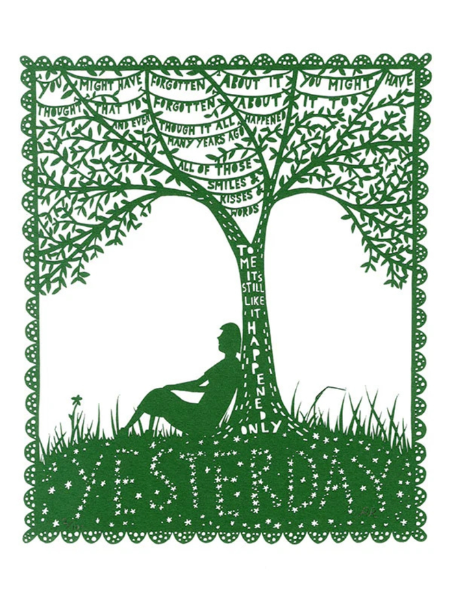 A green lasercut on a white background of a person sitting with their back against a tree. tree branches detailed with a reflective quote.