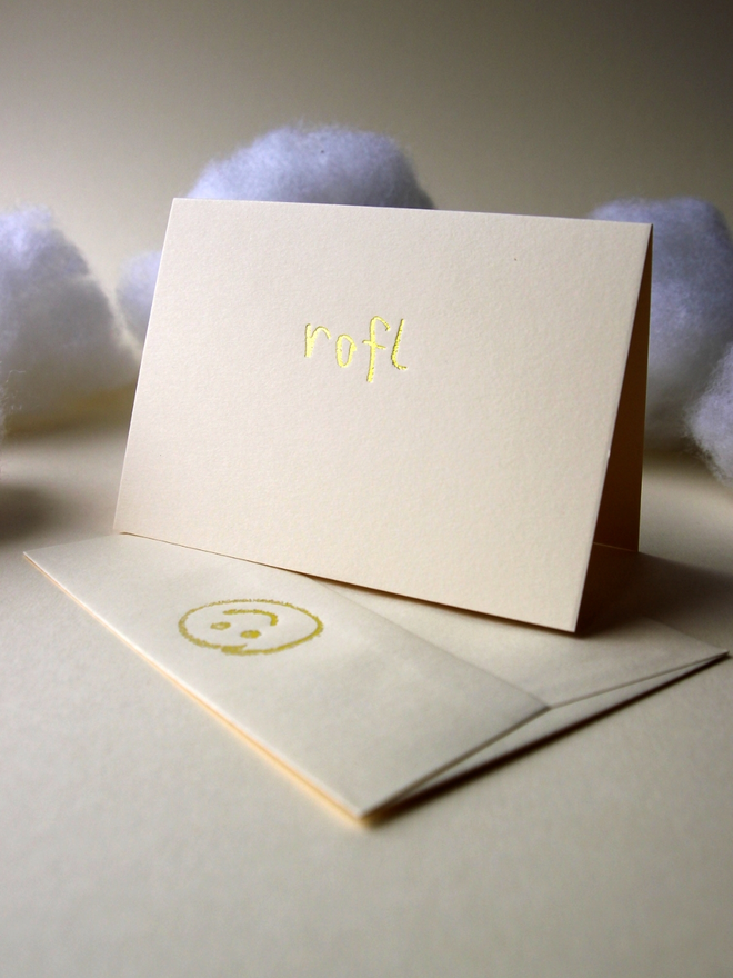 sandy coloured card with rofl short for 'roll on floor laughing' hand foiled in kids hand writing