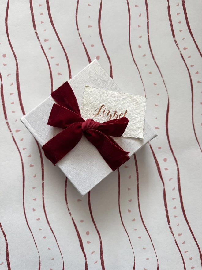 paperweight in white box with red velvet ribbon