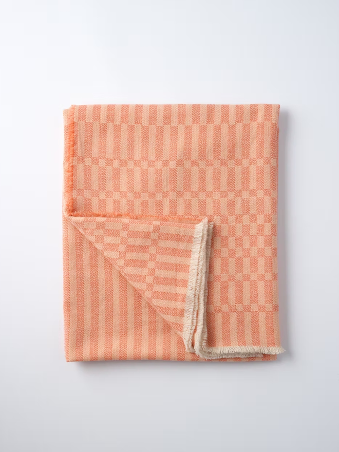 arabella lambswool blanket. a textured pink blanket photographed folded against a white background.