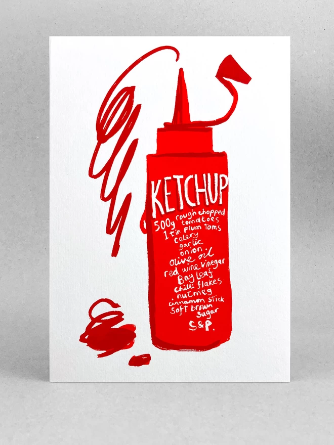 Ketchup recipe is written on a squeezy red bottle, with a scribbled squirt of ketchup jumping out the top - all on a white greetings card stood in a light grey studio space.