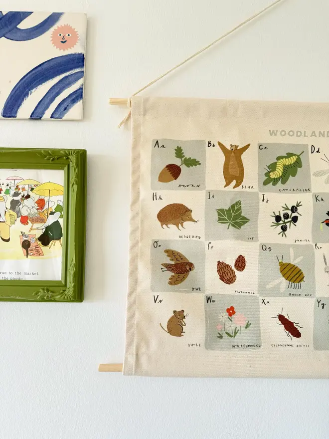 Woodland Alphabet Fabric Banner, hanging on a white wall. 