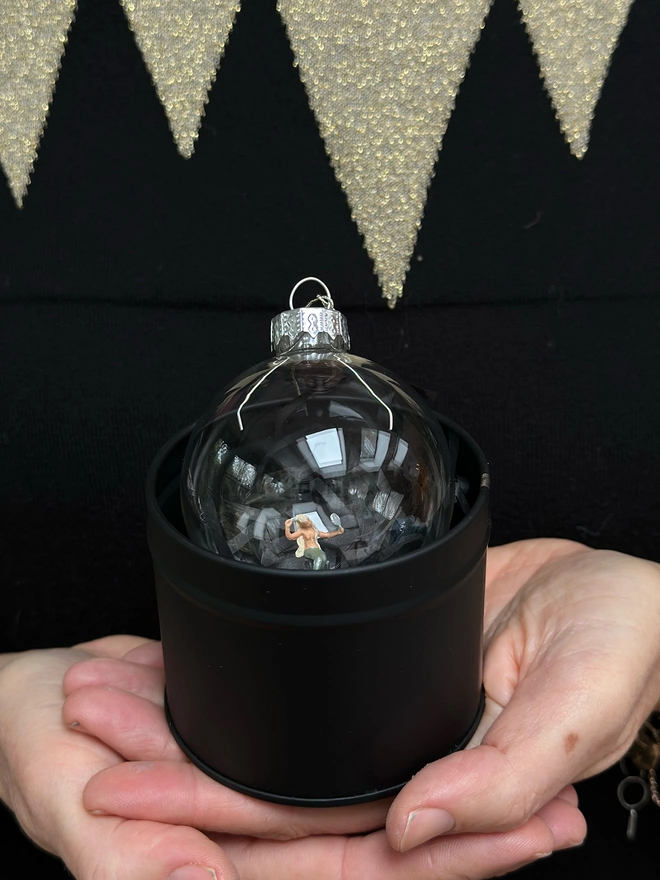 Open tin containing bauble