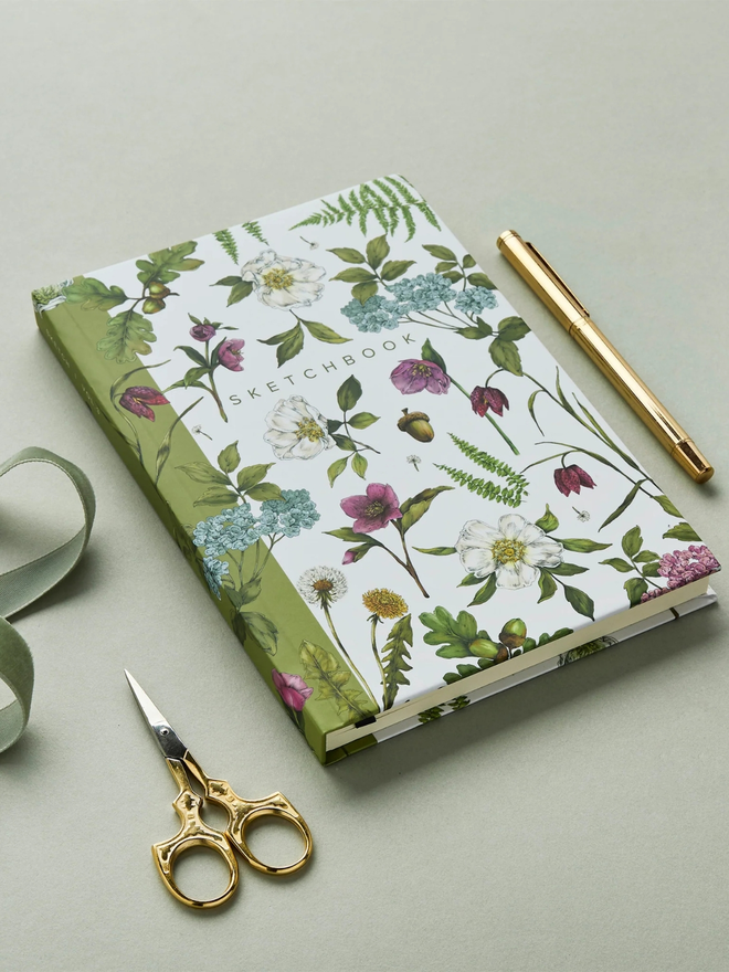 'Cottage Garden' A5 Hardback Sketchbook. a white floral sketchbook photographed on a plain grey background.