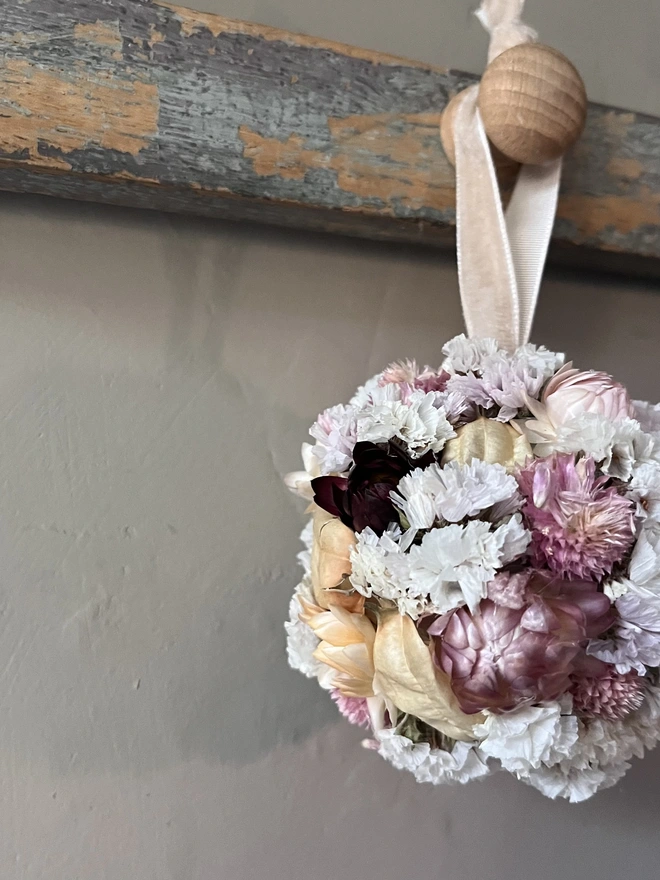 Pink and white dried flower bauble made using a selection of seasonal blooms. 