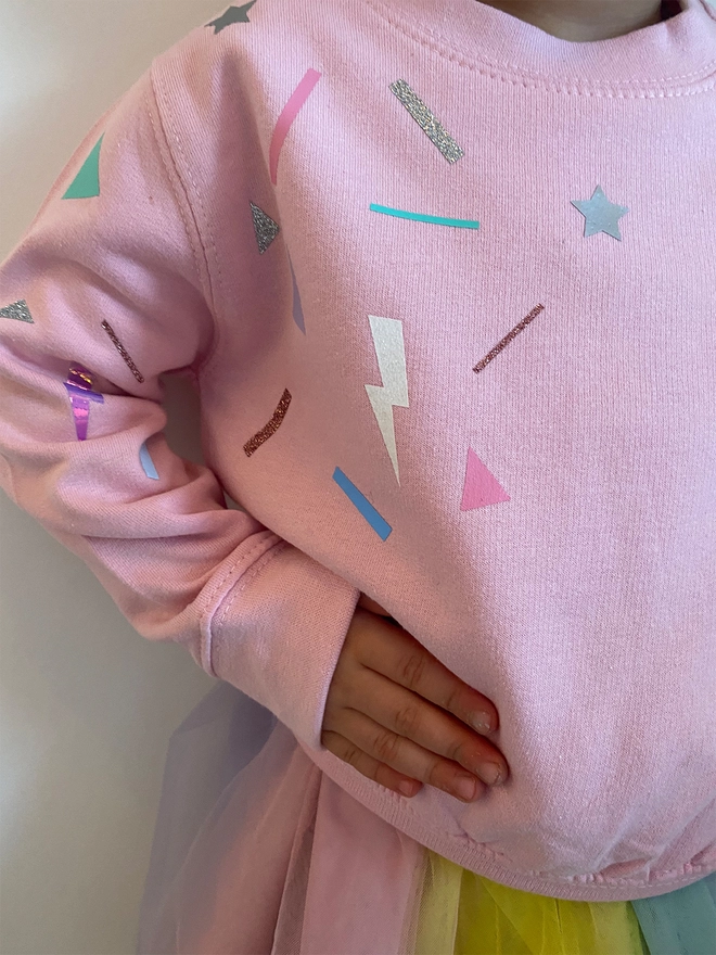 A picture of a candy pink sweater with funfetti print 