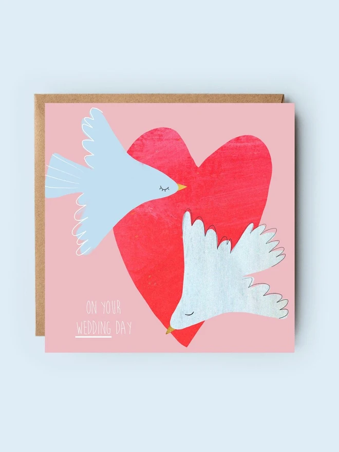 illustrated doves wedding card. card photographed against plain blue background.