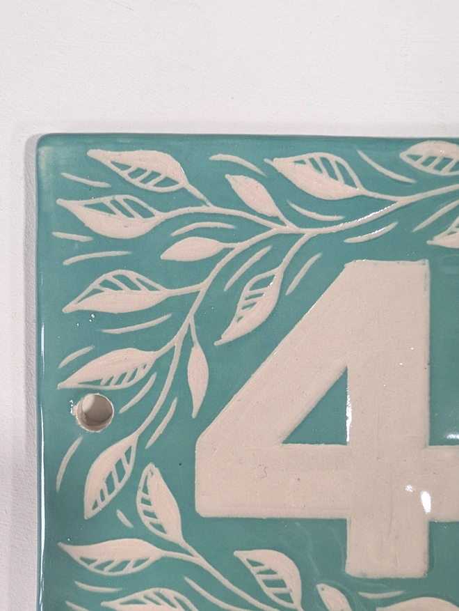 Handmade Ceramic House Plaque with Leaf Pattern. A house plaque in turquoise.