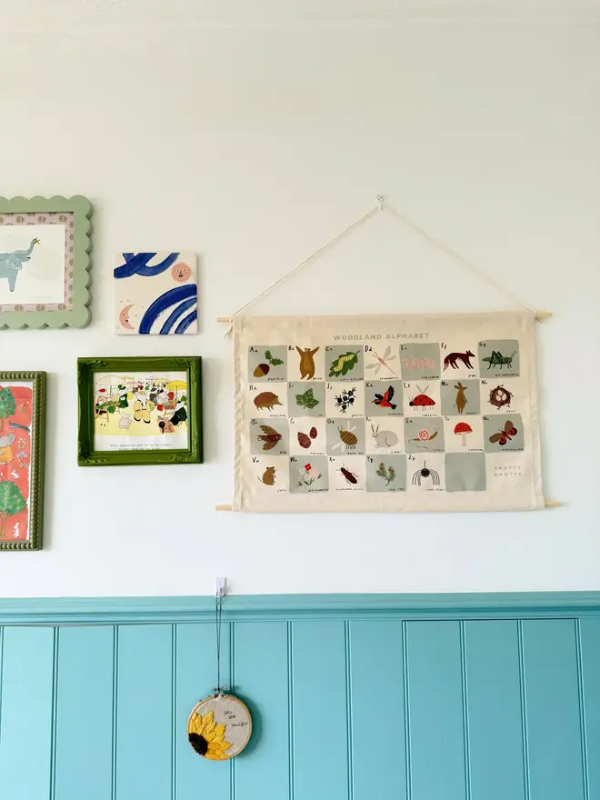 Woodland Alphabet Fabric Banner, hanging on a white wall. 