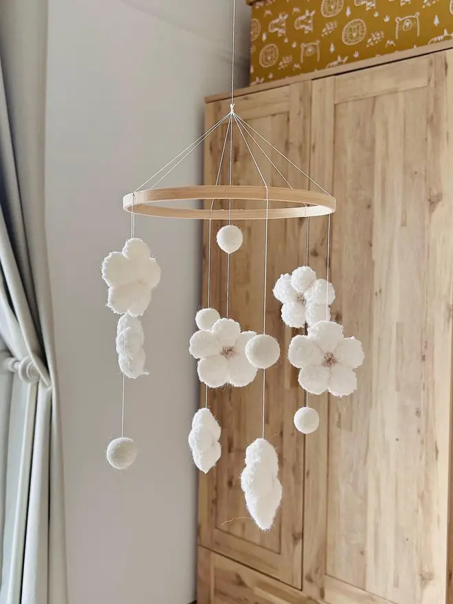 boucle flower baby mobile. a white cloth baby mobile hanging from the ceiling.