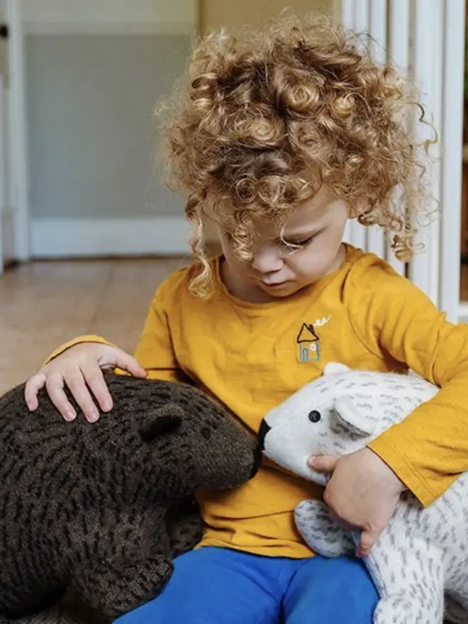 child holding brown and white bears