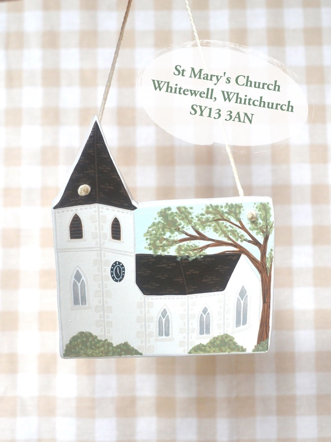 clay hanging design in the shape of a white church with gingham background