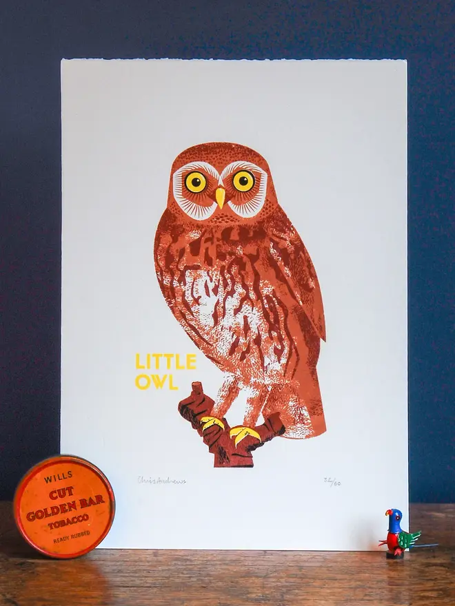  illustrated little owl print. illustrated owl print propped up against navy blue wall bcakground.