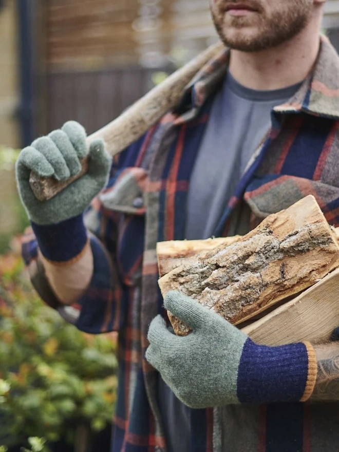 Block Lambswool Gloves, a pair of colourful gloves worn by a man having just chopped wood. 