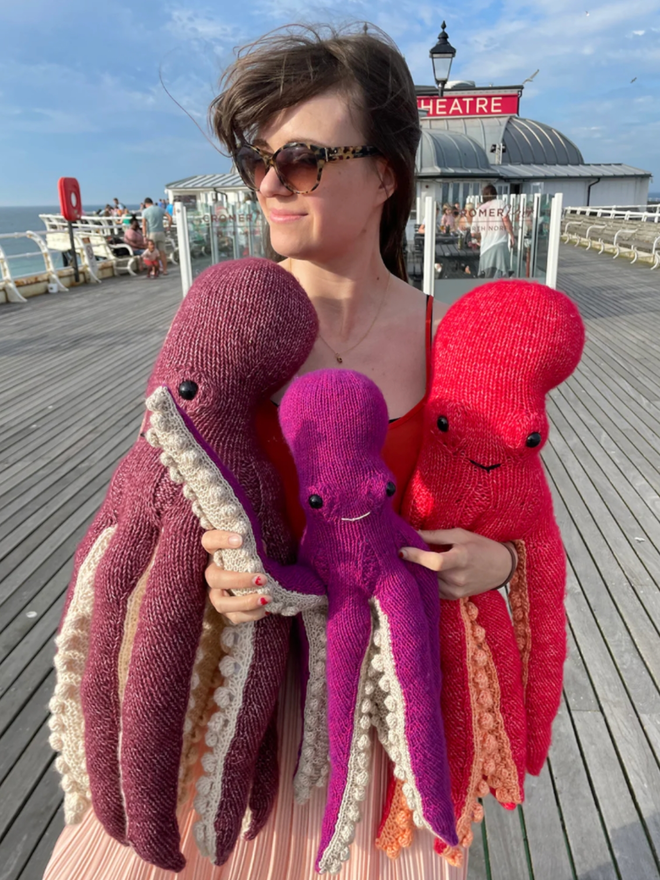 Octopus Knitting Kit. A knitted octopus in mini purple (L), mini bright purple (C), mini red (R)