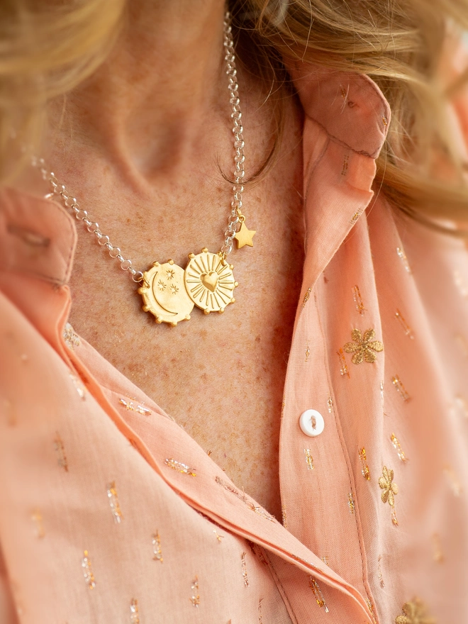 Celebrate love written in the stars with the Lunar Glow Double Coin Necklace. Featuring heart sunburst and moon-and-stars charms engraved with “My sun, my moon and all my stars,” this mixed metal necklace makes a thoughtful gift or personal keepsake. Finished with a delicate star charm, it’s celestial jewellery full of meaning and warmth.