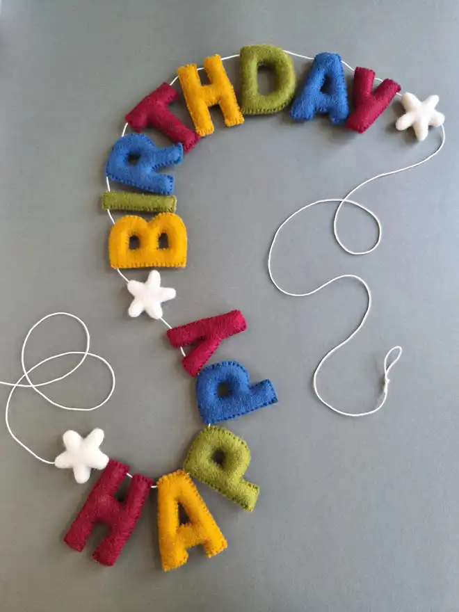 Felt hand stitched letters featuring the word 'Happy Birthday' in gorgeous rich tones