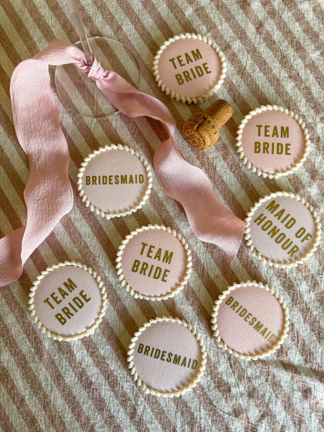 Pink Hen Party badges including bridesmaid and made of honour and team bride. Pink Badges with a pom pom trim and gold lettering for hen party and bridal shower