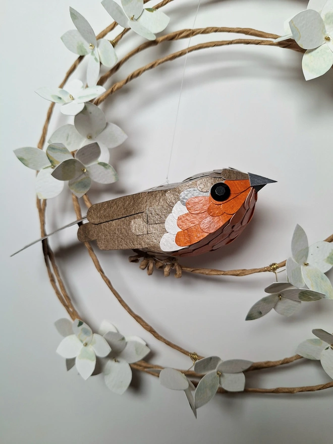 close up of a robin sculpture, made from handprinted papers
