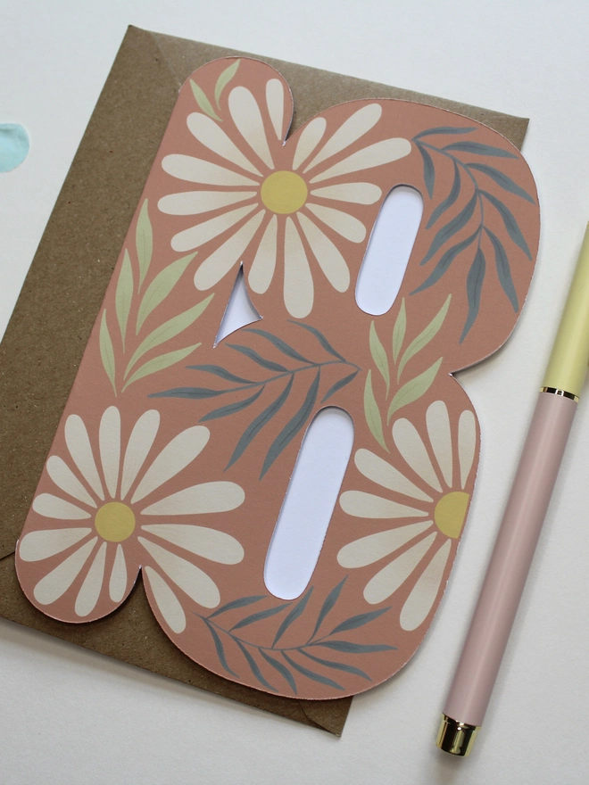 floral 18th birthday card. card shaped like number 18 with daisies and leaves.