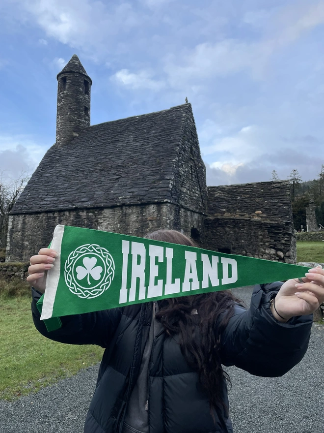 felt pennant flag rich pea green with white text saying IRELAND and a shamrock in a celtic patterned border