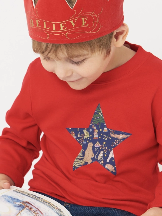 a 4 year old boy wearing a Christmas t-shirt with a  liberty print star appliquéd on the front