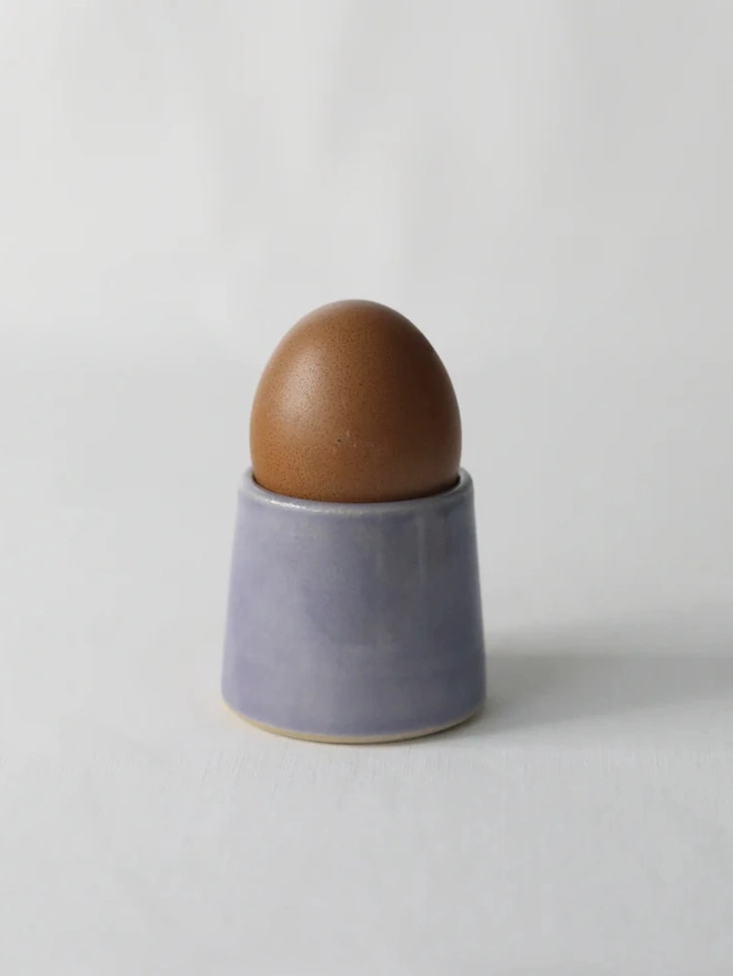 Classic Handmade Egg Cup, a ceramic egg cup sitting on a plain surface against a white backdrop. 