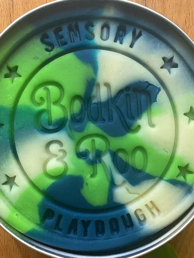 earth sensory play dough. a tub of earth blue and green play dough.