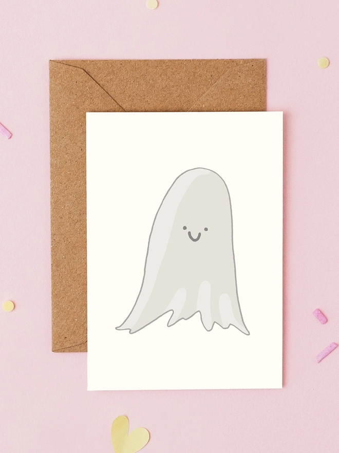 Hand drawn mini Halloween greeting card featuring a smiling white ghost on a cream background. Cute ghost card for Halloween and spooky season by You've Got Pen On Your Face.