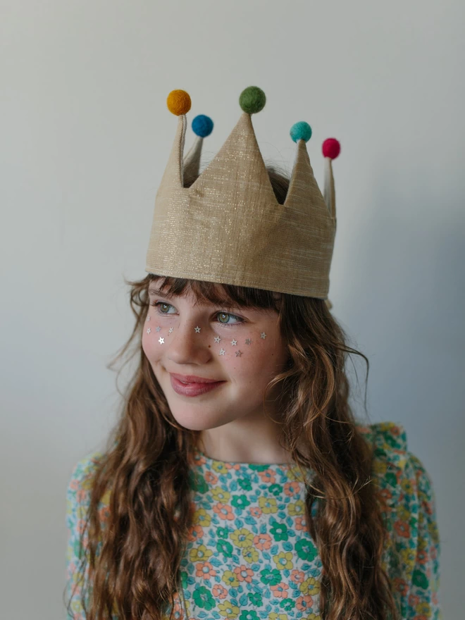 Girl in gold crown with pom poms