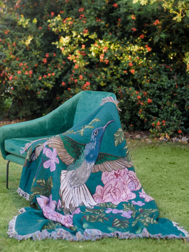 Joy Hummingbird Woven Blanket on chair