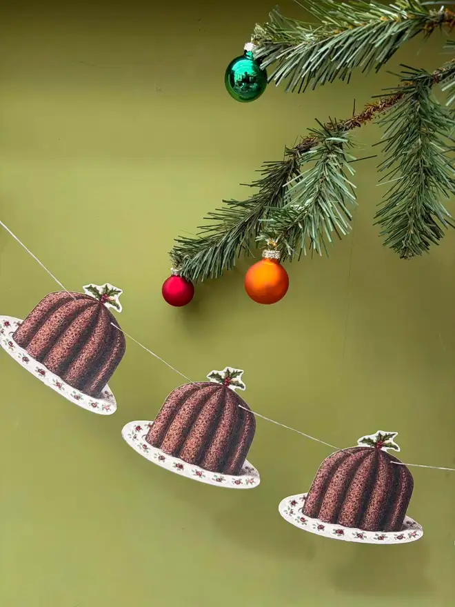 Paper cut out Christmas puddings strung as bunting