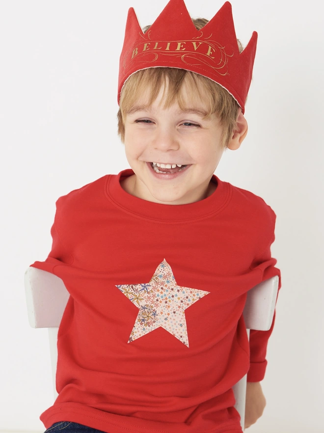 a 4 year old boy wearing a red tee with a christmas star cut from starry liberty print sewn onto the front