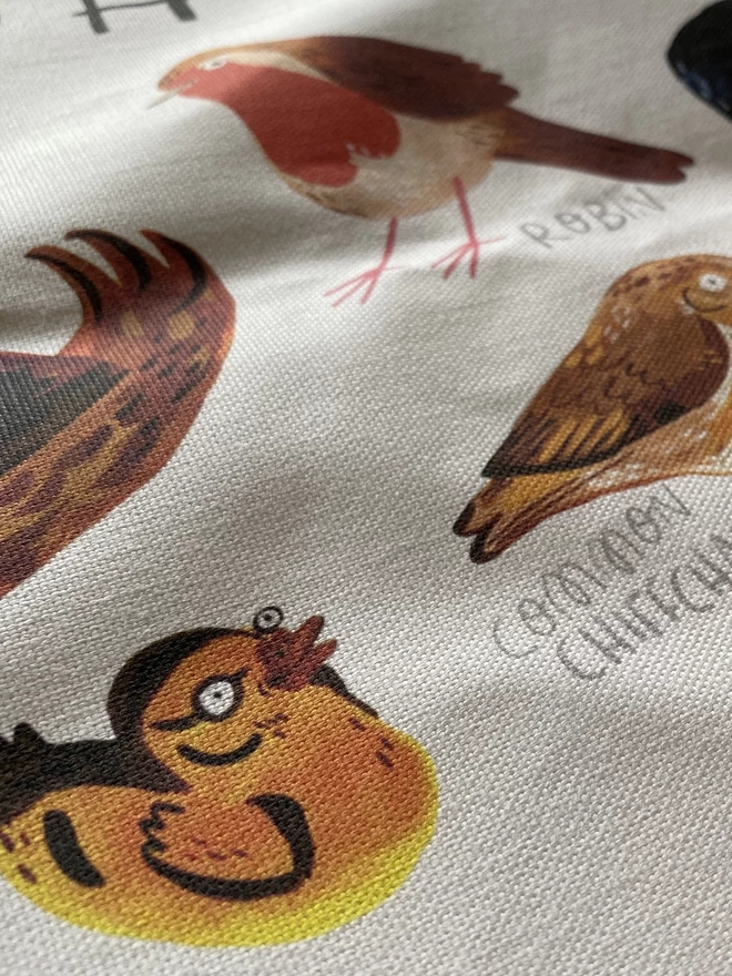 Detail of British Birds illustrated tea towel with over 12 varieties of birds digitally printed on cotton fabric