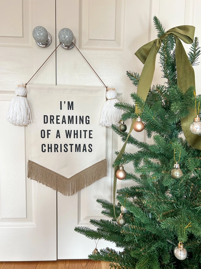 I'm dreaming of a white christmas fabric banner with white tassels and a christmas tree