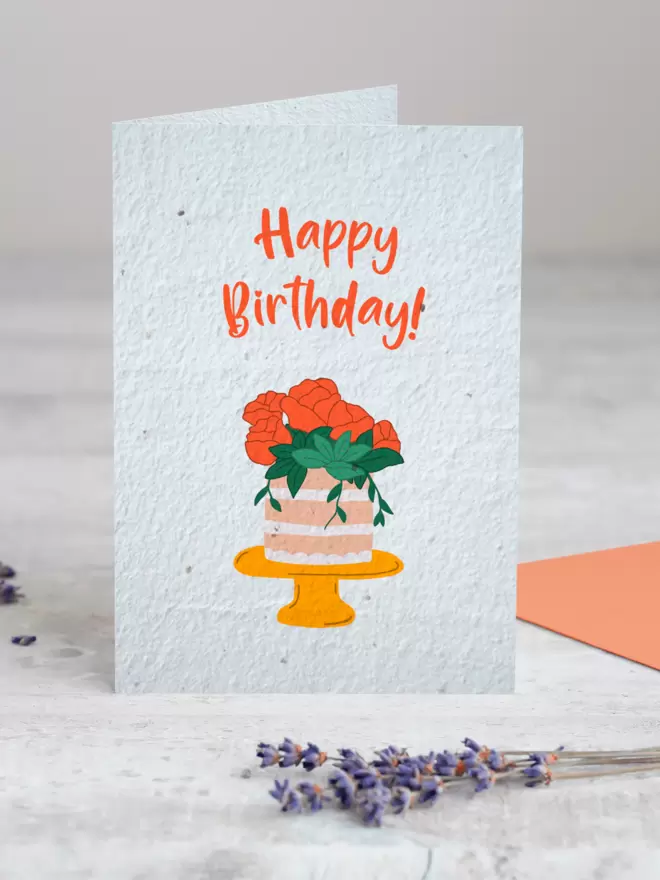 Plantable Card with Happy birthday and an illustration of a cake with roses on with a sprig Lavender in the foreground
