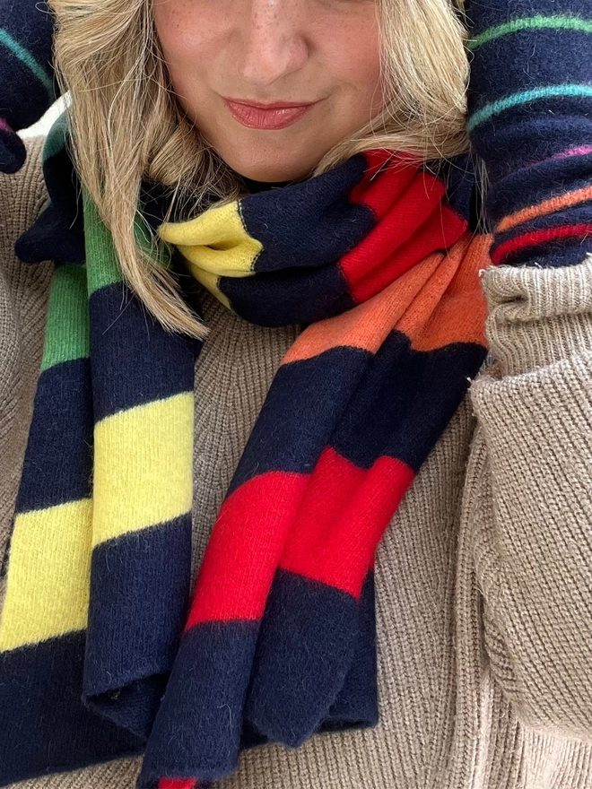 Navy scarf with colourful stripes worn with matching wristwarmers