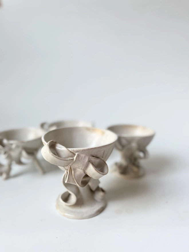 larger ceramic bowl with three smaller similar bowls in background