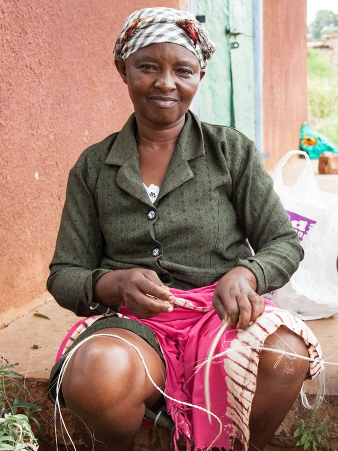 Kenyan lampshade weaver rolling sisal