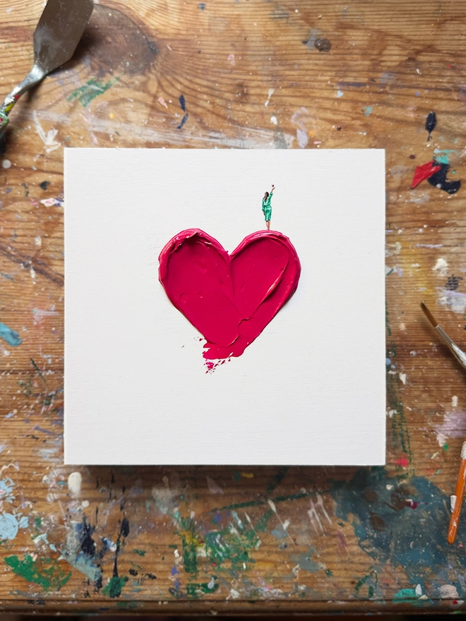 woman holding a wine glass standing on top of a tinted red heart