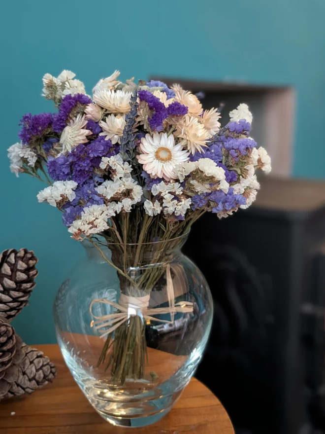 lavender sea spray dried flower bouquet. bouquet of purple dried flowers in a round glass vase.
