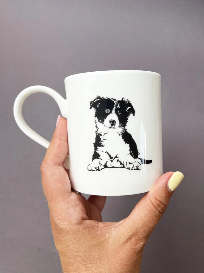 The back of the mug has a fluffy puppy collie sat down 